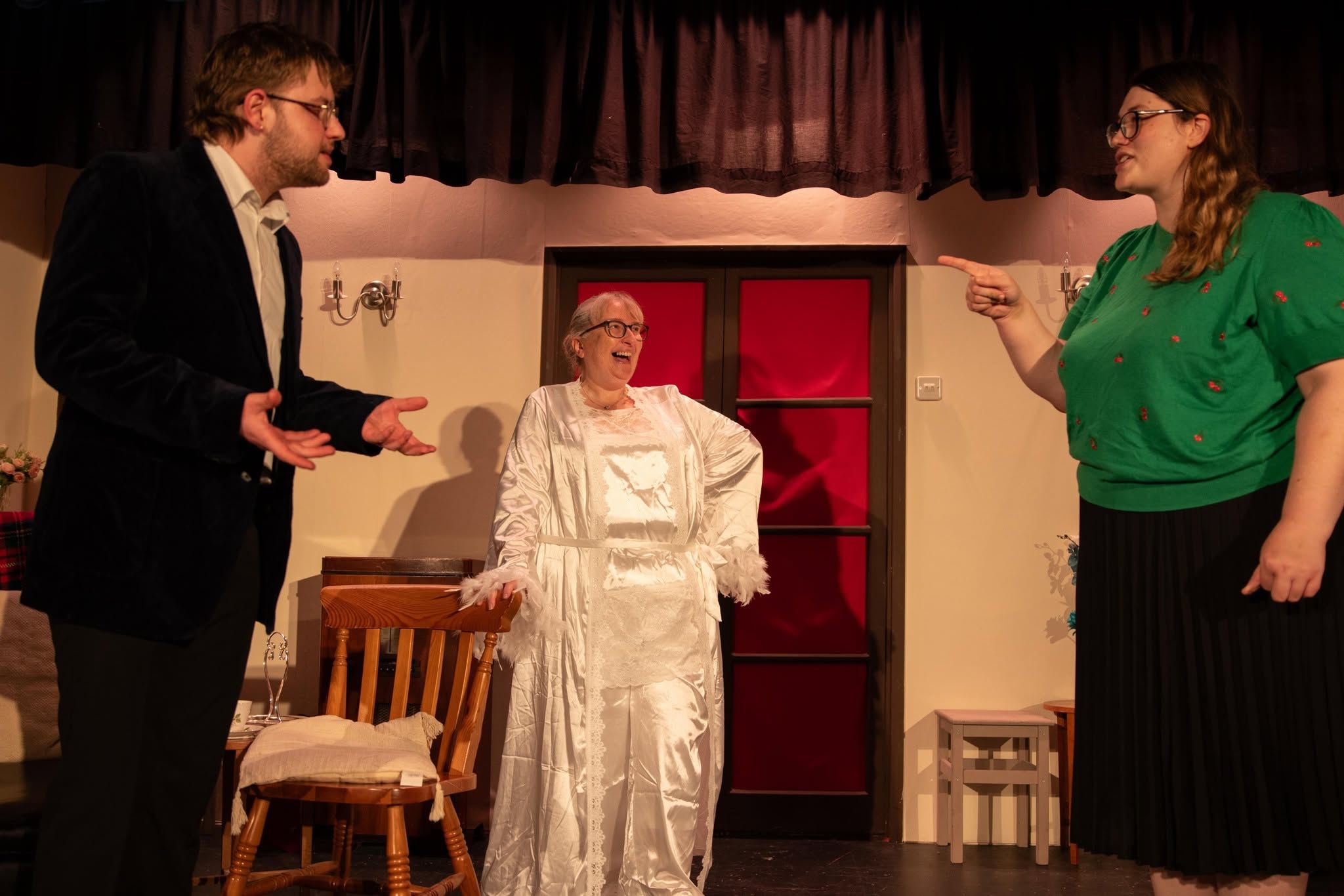 Three Blithe Spirit cast members perform together on the drawing-room set